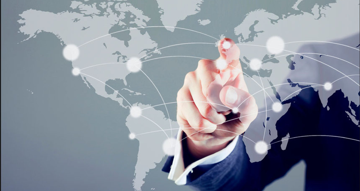Main désignant un réseau mondial de connexions sur une carte du monde